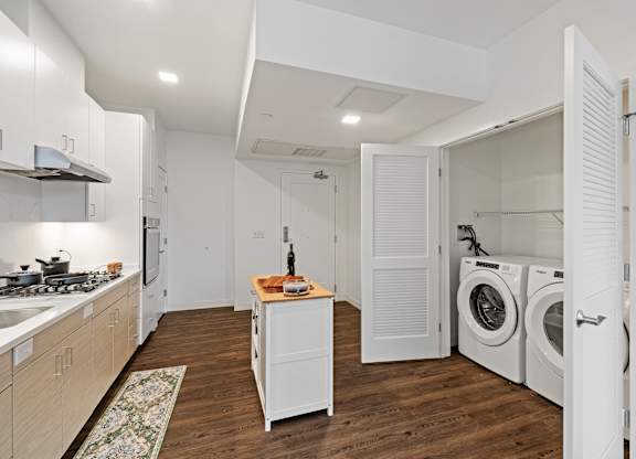 A kitchen with a washing machine and dryer in the laundry room. at Trio Newton Apartments, Apartments, Newton, MA
