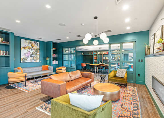 A living room with a green couch and a fireplace at Trio Newton Apartments, Massachusetts