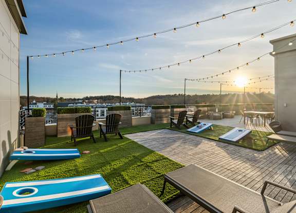 A rooftop patio with a slide and a table set up for dining. at Trio Newton Apartments, Massachusetts