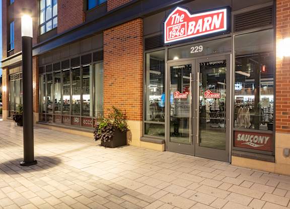 The Barn 1964 storefront at night at Trio Newton Apartments, Massachusetts, 02460
