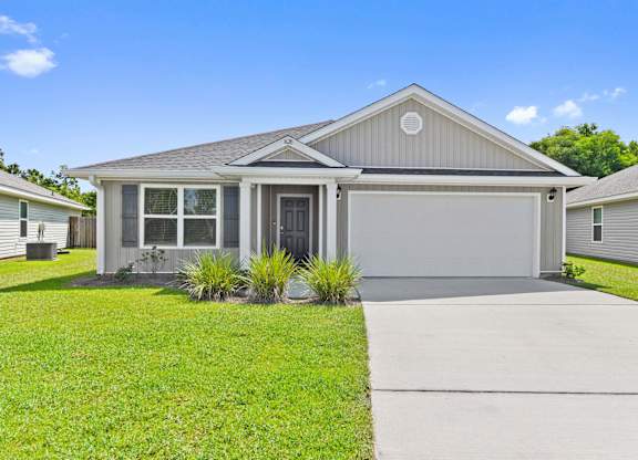 Single-story gray house with a white garage door and green lawn.