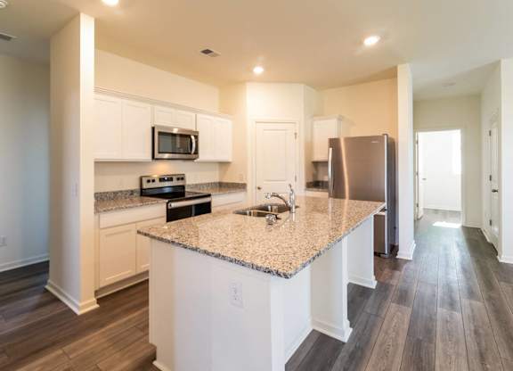 a kitchen with white cabinets and a granite counter top