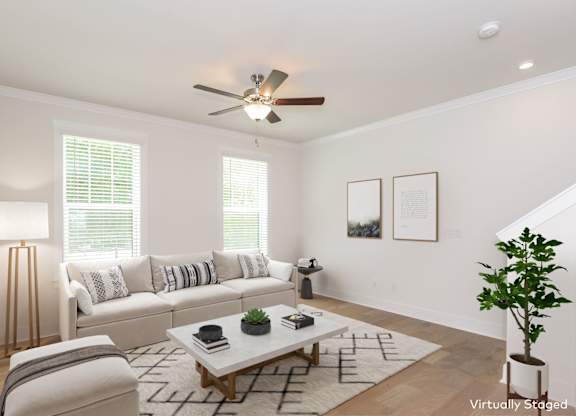 Charlotte, NC Luxury Apartments For Rent - Loso Walk - Living Room With A Ceiling Fan, Windows, And Vinyl Plank Flooring Next To The Staircase