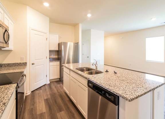 a kitchen with granite counter tops and stainless steel appliances