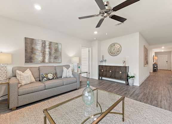 Living room with gray sofa, glass coffee table, and decorative accents.