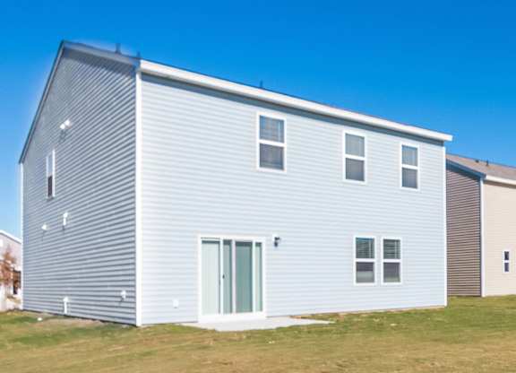 a white house with blue siding and a green door