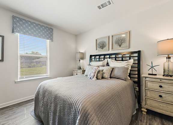 Bedroom with gray quilted bedding, black headboard, and coastal decor.