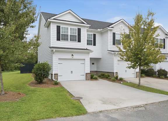 A two-story house with a garage and a driveway.