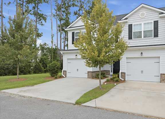 A two-story house with a white garage door.