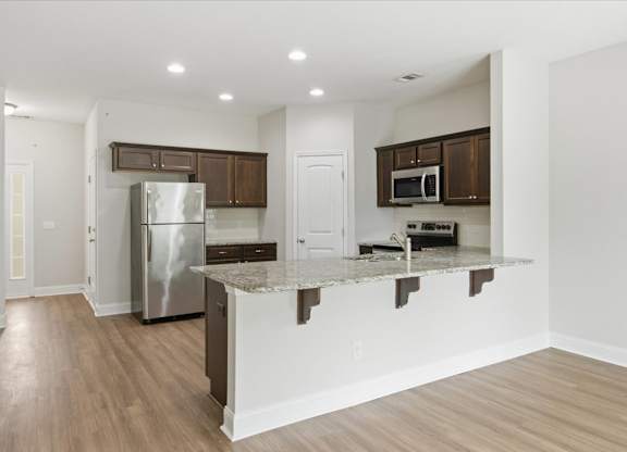 A kitchen with a white island and stainless steel appliances.