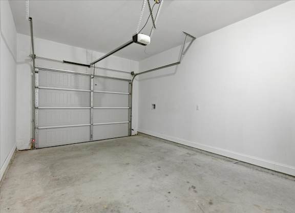 A white wall with a garage door opener.