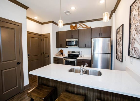 a kitchen with a white counter top and a stainless steel refrigerator