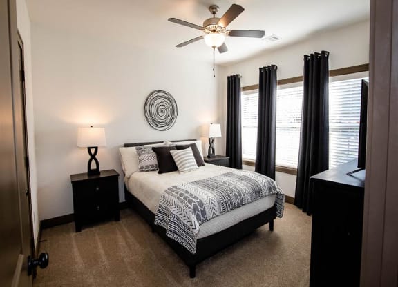 a bedroom with a bed and a ceiling fan