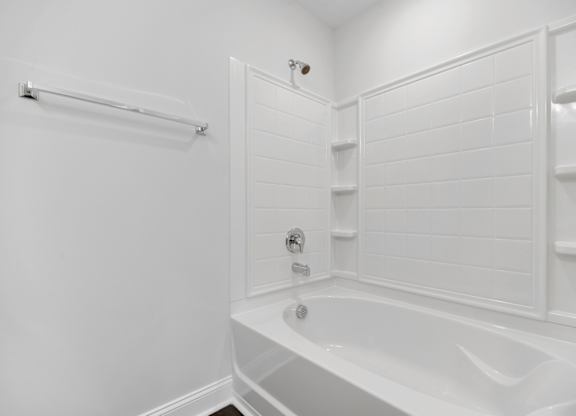 a white bathroom with a white tub and a shower