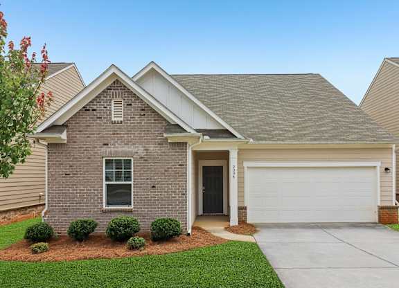 A house with a grey roof and a white garage door.