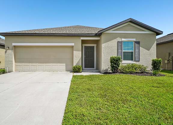 A house with a garage door and a driveway.