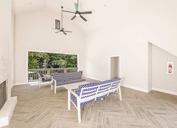 A living room with a couch and a fan.