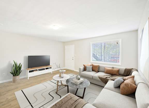 Living room with sectional sofa, television, and modern decor.