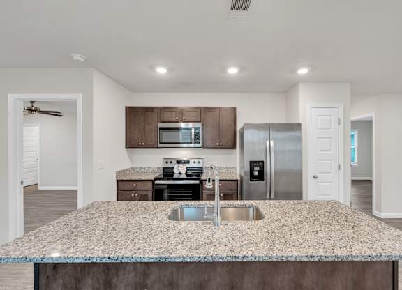 A kitchen with granite countertops and stainless steel appliances.