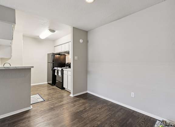 A kitchen area with a refrigerator, microwave, and oven.