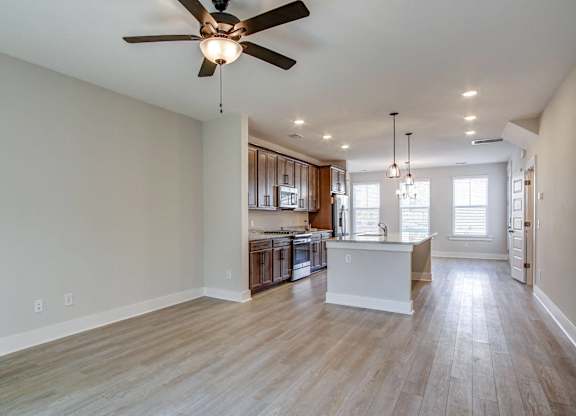 an open kitchen and living room with a ceiling fan