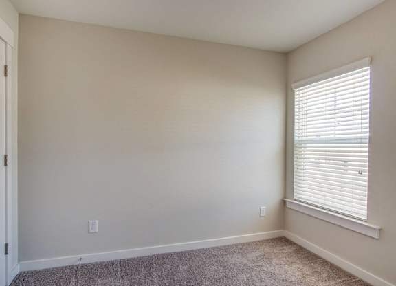 an empty room with a window and a door