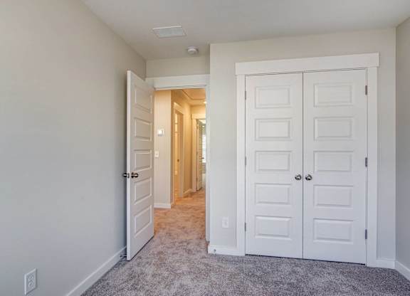 a bedroom with two closets and a hallway leading to a closet