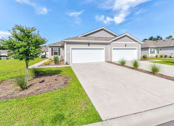 a house with a driveway and a garage door in front of it