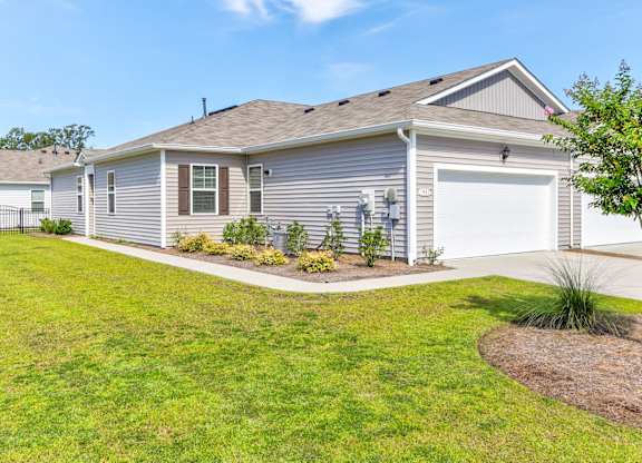 a blue house with a garage and a lawn