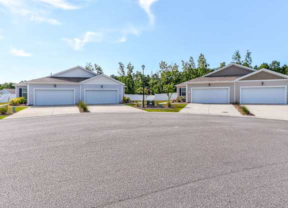 a house with two garages and a street in front of it