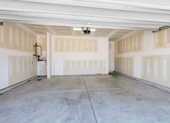 the inside of a garage with white walls and a concrete floor