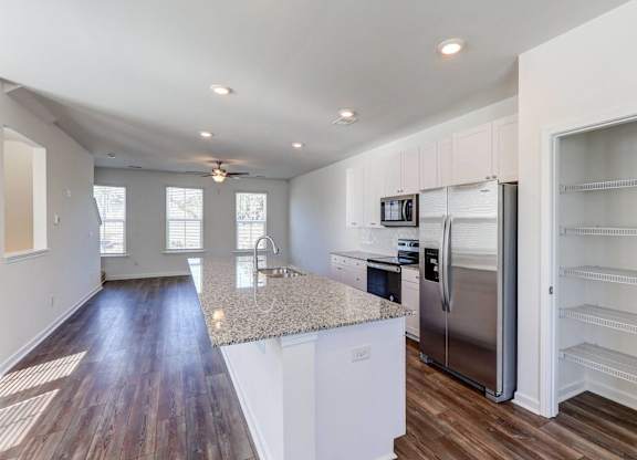 a kitchen with a granite counter top and a stainless steel refrigerator