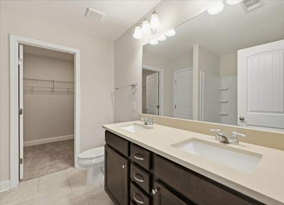 A bathroom with a sink, mirror, and toilet.