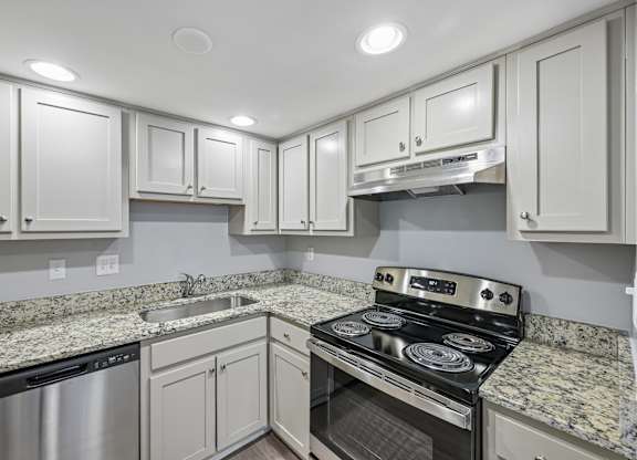 A kitchen with granite countertops and stainless steel appliances.