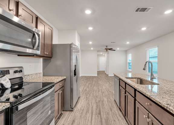 A modern kitchen with a stove top oven and a refrigerator.