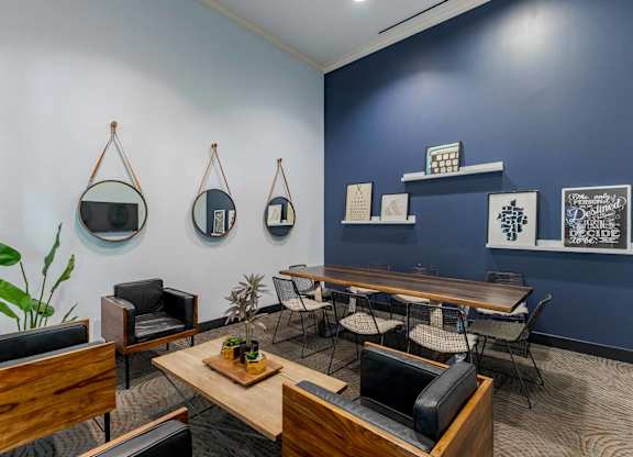 A room with a blue wall and a wooden table with chairs.