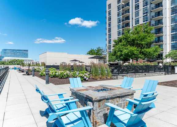 A patio with blue chairs and a table.