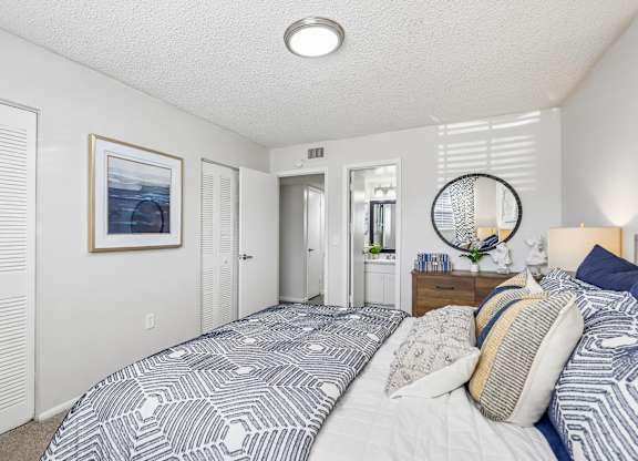 A bedroom with a large bed and a picture on the wall.