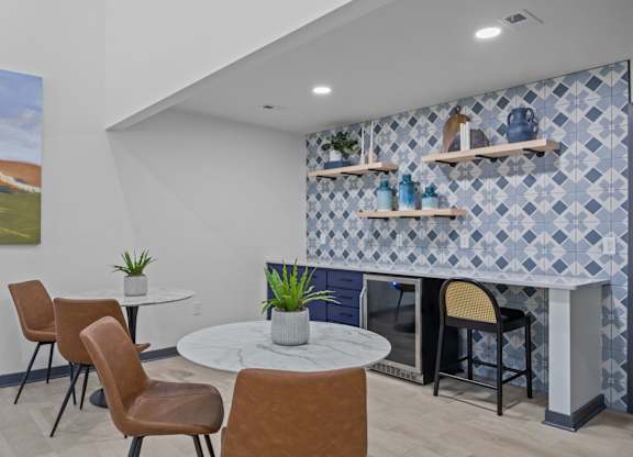 A room with a table, chairs and a painting on the wall.