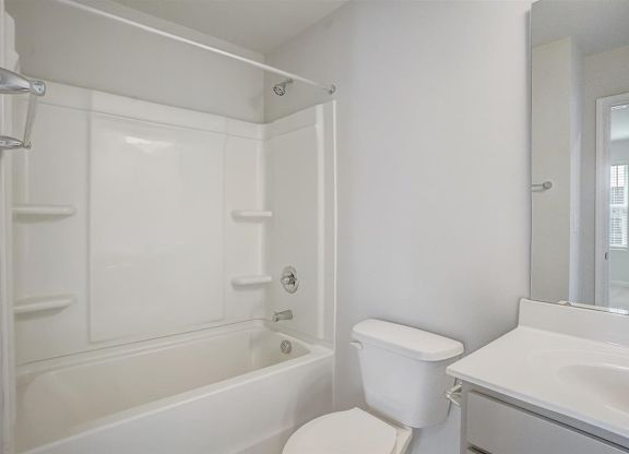 A white bathroom with a toilet, sink, and bathtub.