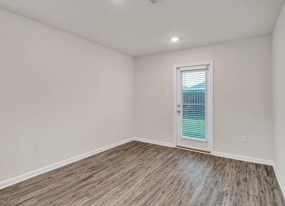 A room with a wooden floor and a white door.