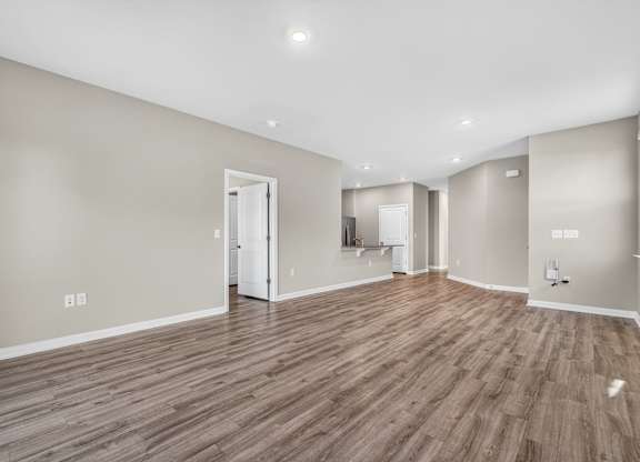 A room with wooden flooring and white walls.