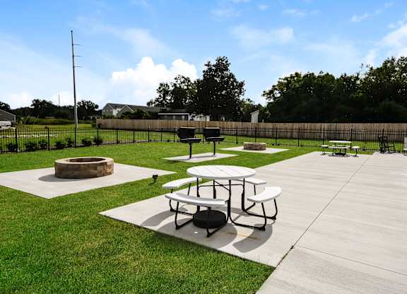 A picnic area with tables and a fire pit.