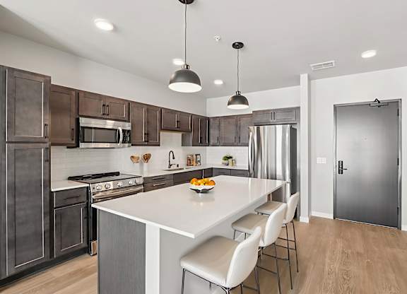 A modern kitchen with a large island and stainless steel appliances.