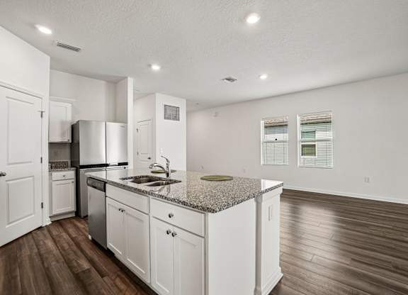 A kitchen with white cabinets and a granite countertop.