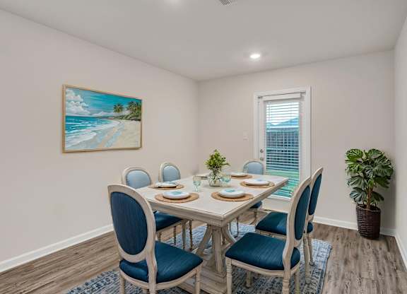 A dining room with a table set for four.