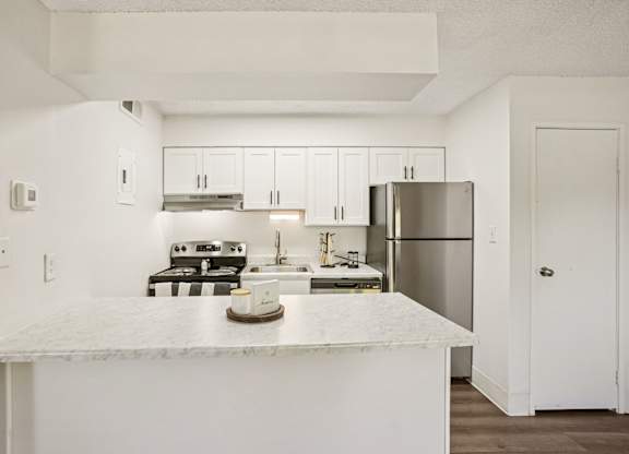 Updated kitchen with white cabinets and stainless-steel appliances at Willowstone Apartments in Denver, CO
