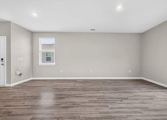 A room with wooden flooring and a window.