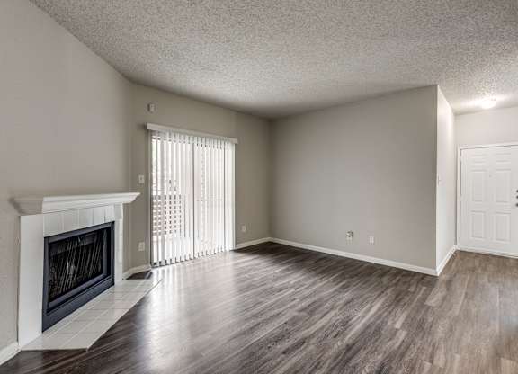 A room with a fireplace and wood flooring.