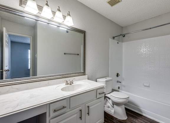 A white bathroom with a sink, toilet, and bathtub.
